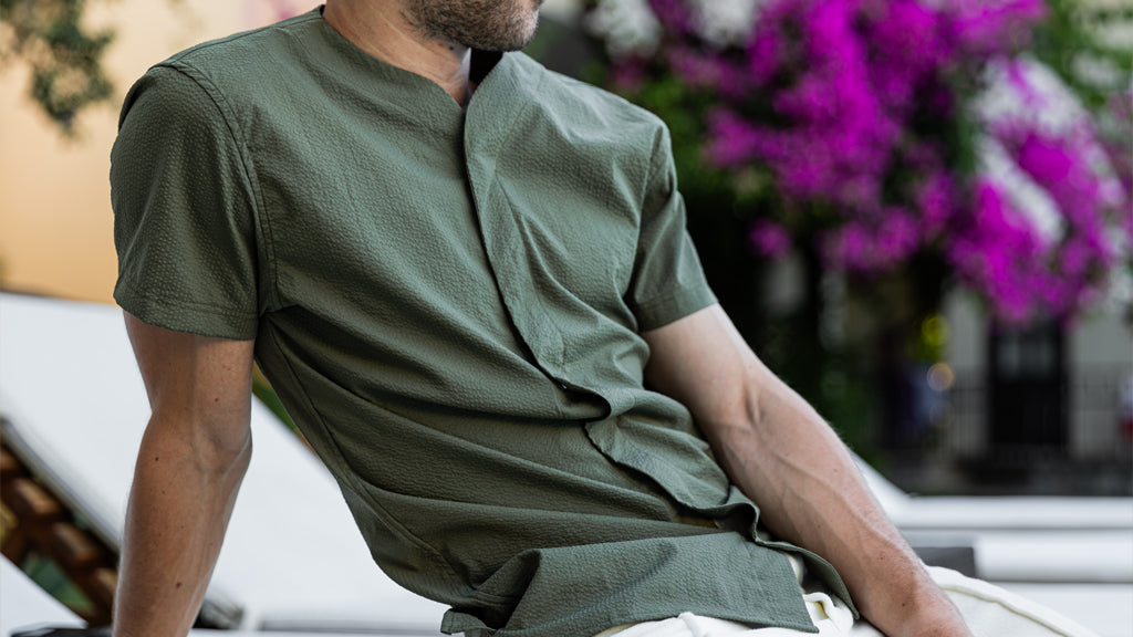 Man wearing Cheegs SeerTech™ Collarless Short Sleeve Dress Shirt in Khaki on a Lounge Chair in Spring