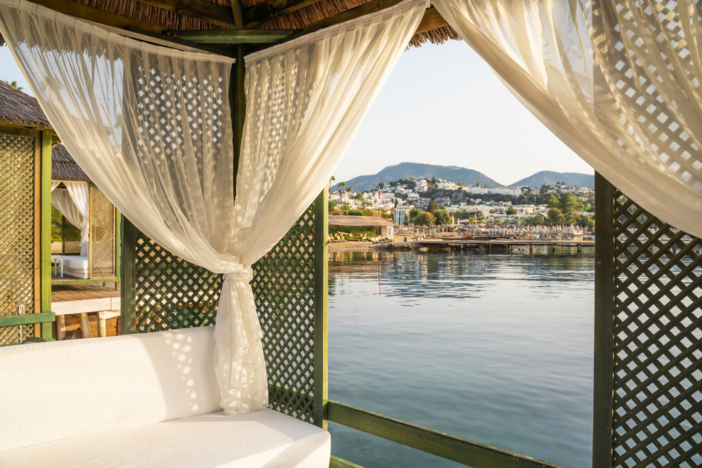 coastal gazebo with engineered thatch roof and linen curtains