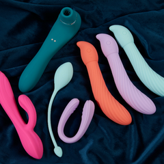 A variety of sex toys on a emerald, blue blanket