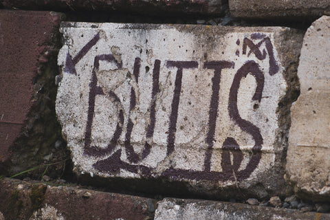 image of stone with writing on it that reads butts
