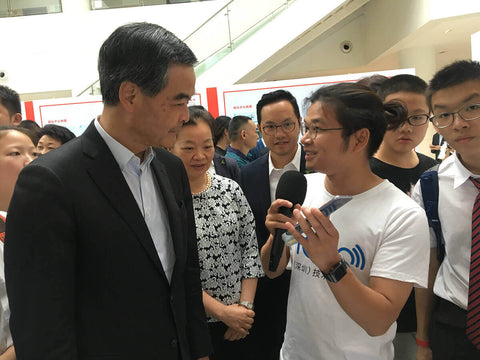 Two men conversing in front of crowd