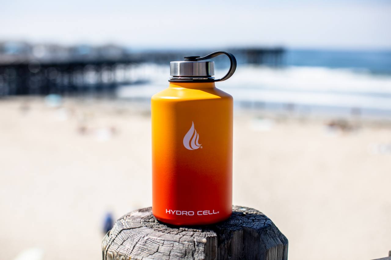 An orange water bottle on a tree stump