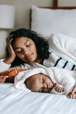 A mother watches as her baby sleeps soundly