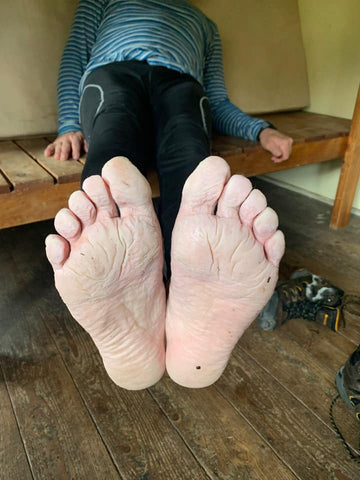 women showing her wrinkled and damp feet to the camera after a hike