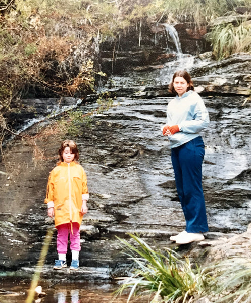 young girl and mum standing by some rocks