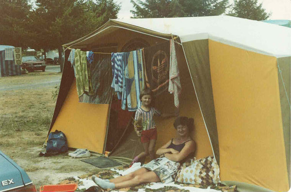 Lady and a child standing in front of a tent