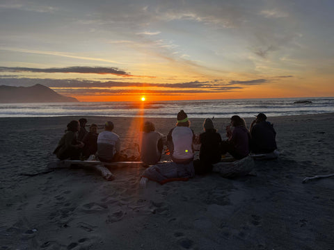 Sunset on the West Coast people sitting on a log