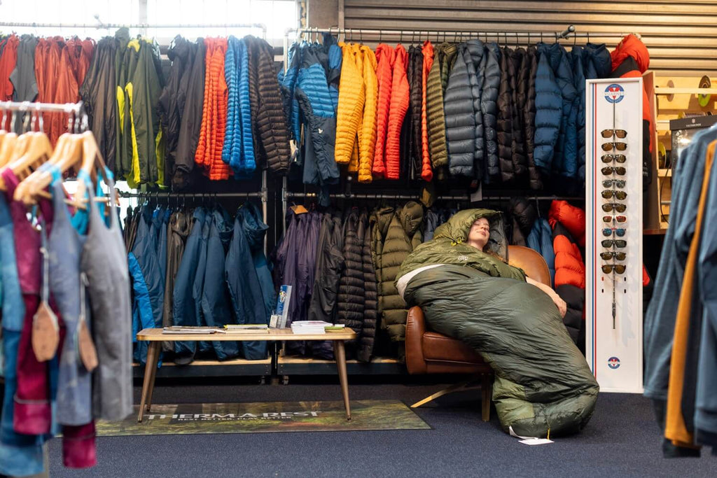 Lady sleeping in a sleeping bag in a store