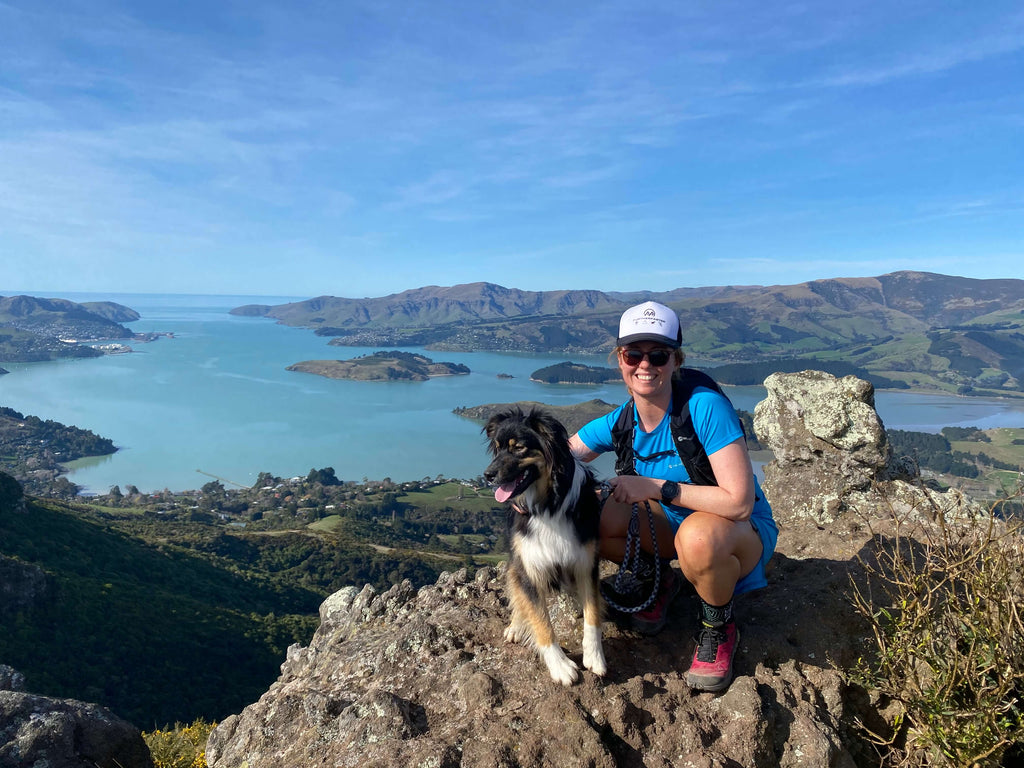 holly weston running on coopers knob with a dog in christchurch port hills