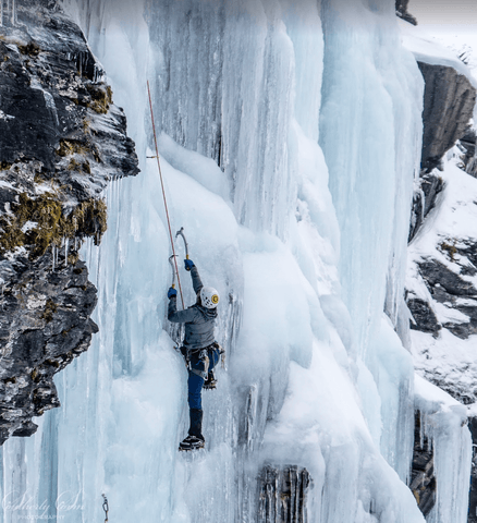 woman ice climbing on ice wall