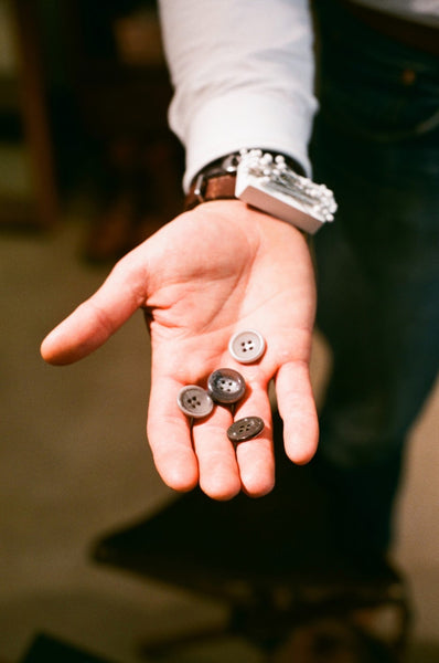Man holding some buttons in his hand