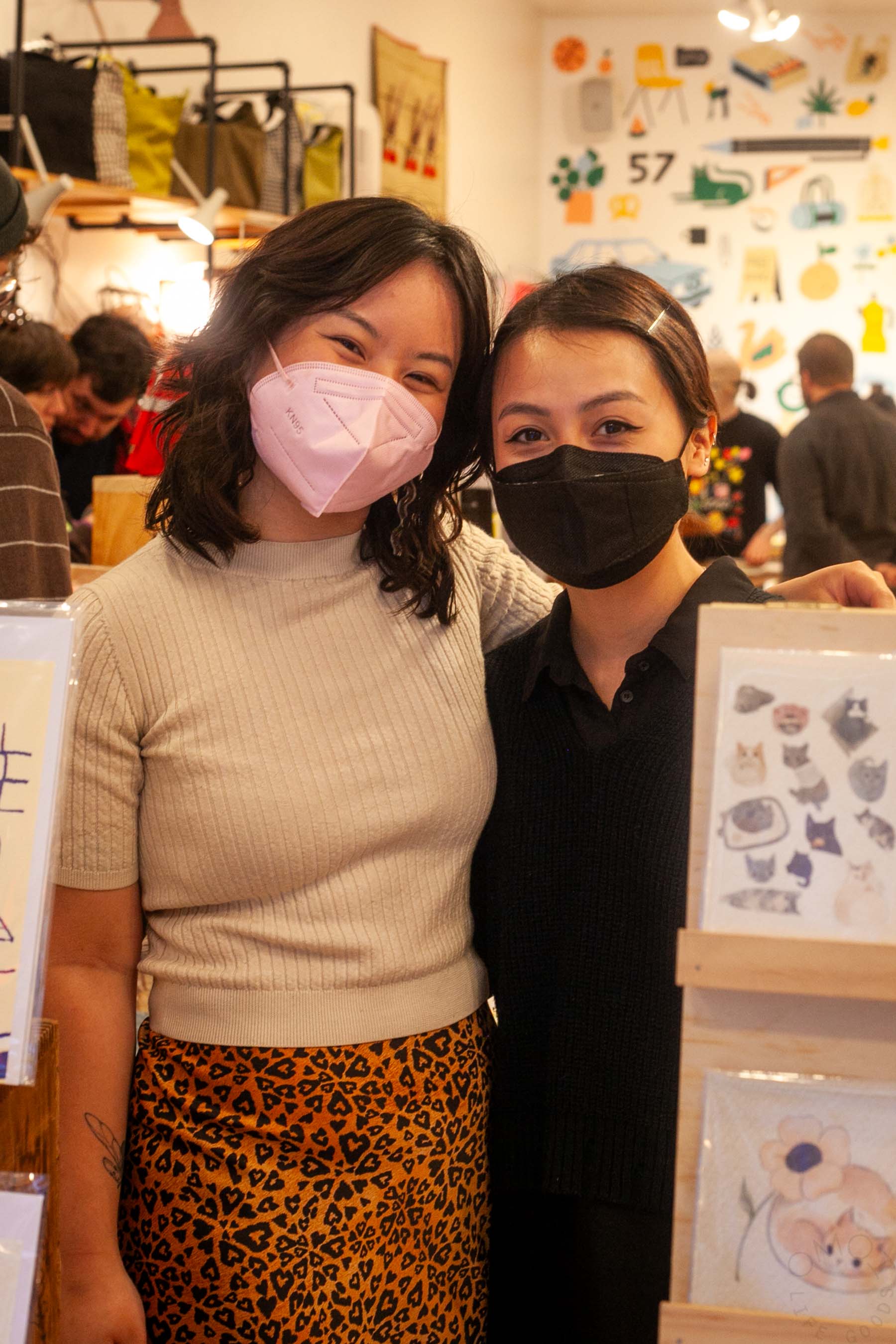 Hannah poses with shop staff V who organized the First Friday. Both wear masks.