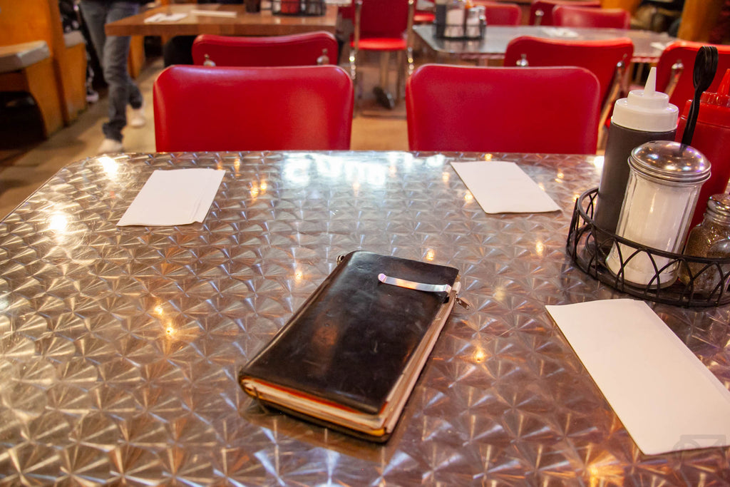 Our online director's TRAVELER'S notebook sitting on a diner tabletop