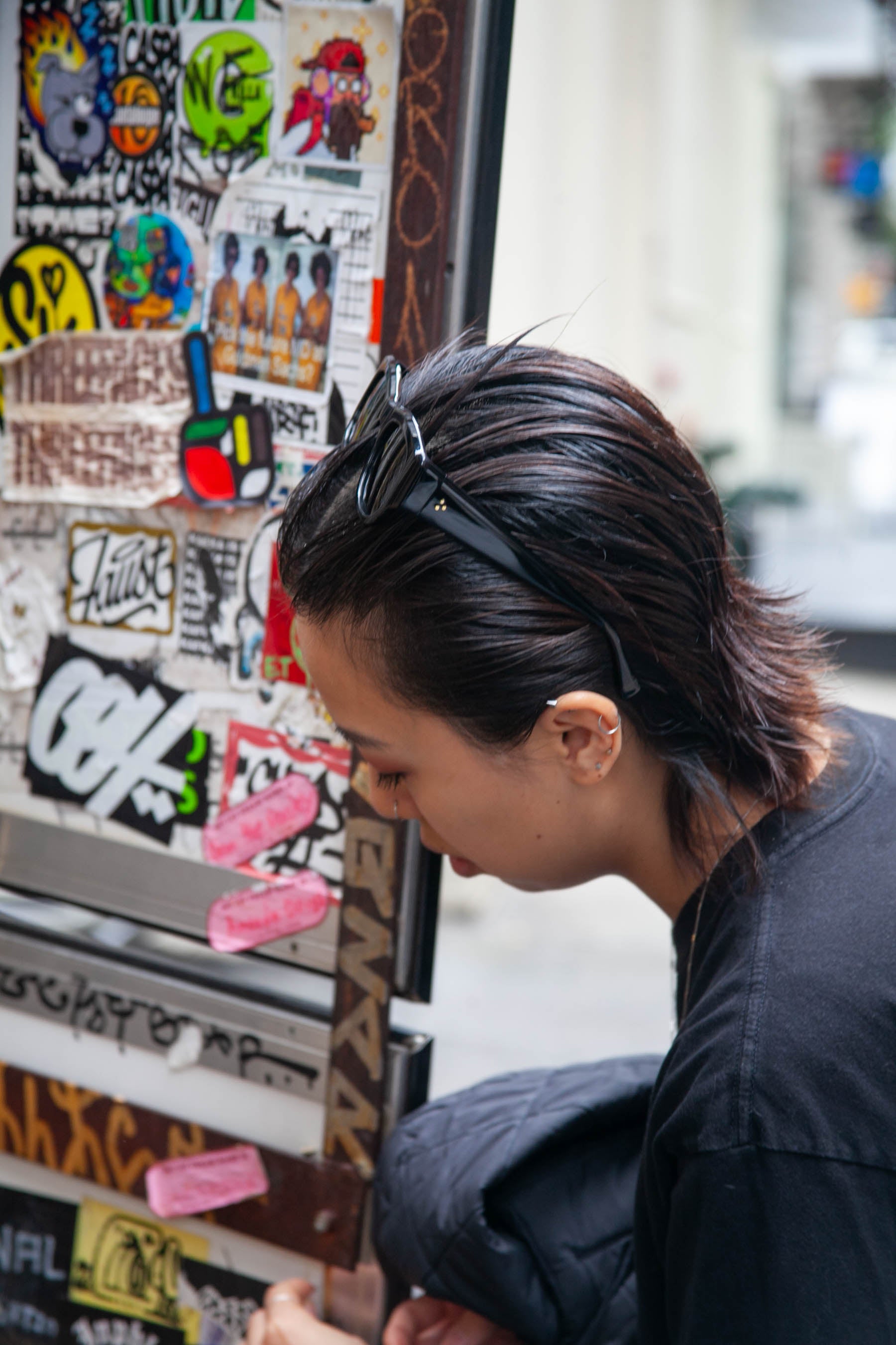 Model checks out the stickers on the back of a sign in SoHo, NYC