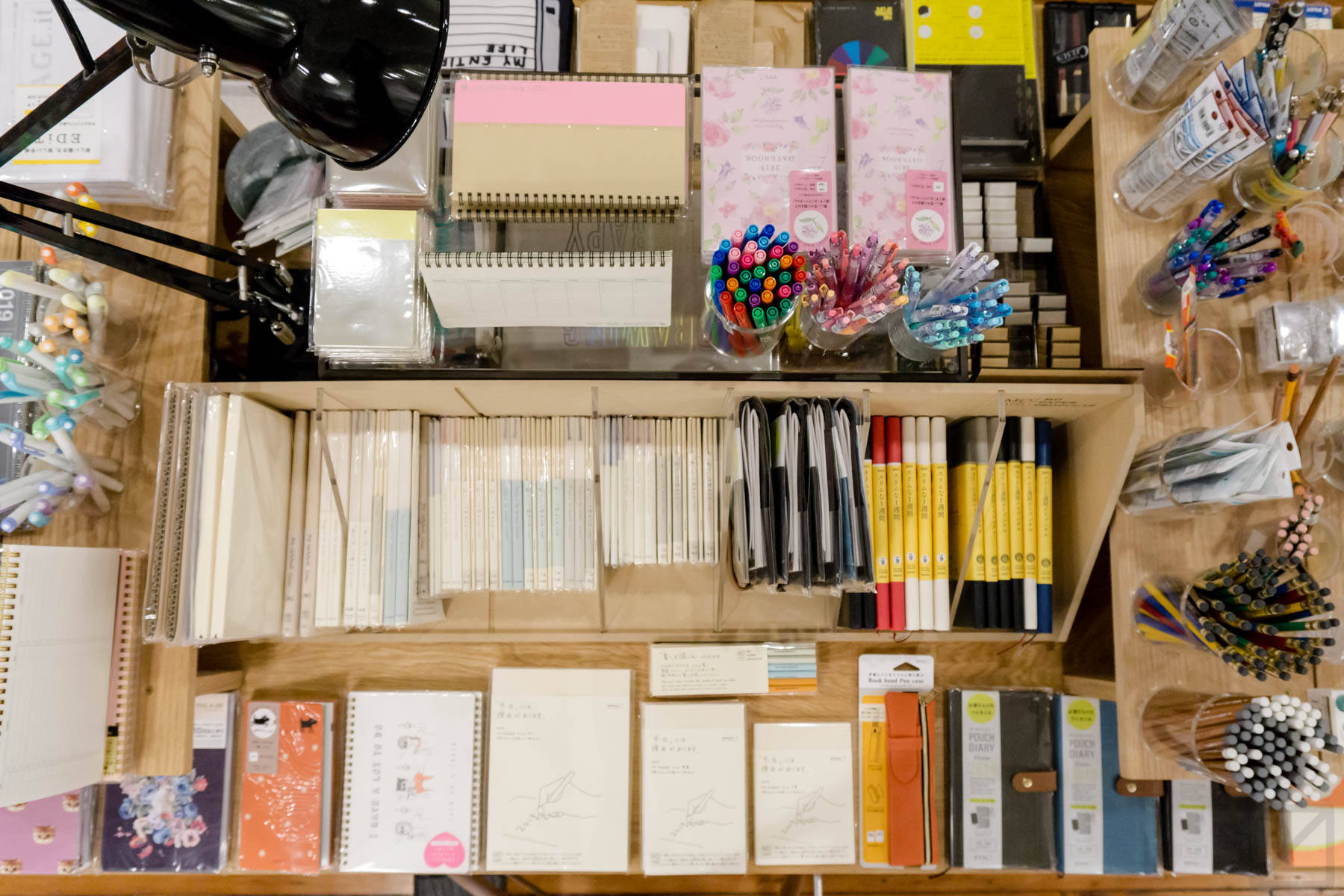 An overhead shot of one of several stationery displays. Planners, MD Paper notebooks, writing utensils, and more