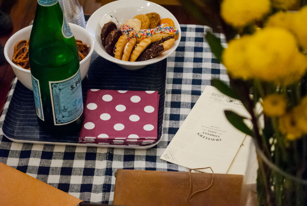 cookies, pretzels, and sparkling water for guests, sitting on a gingham tablecloth