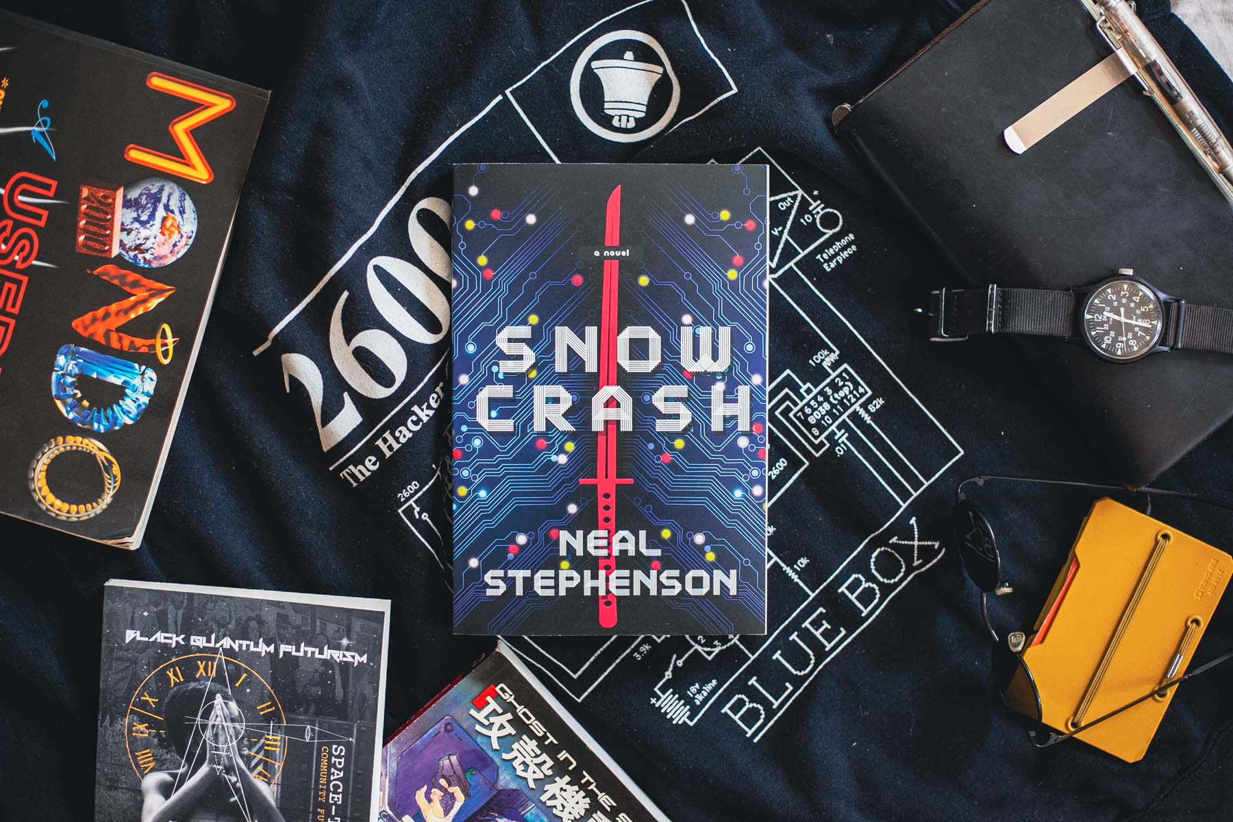 The <em>Snow Crash</em> book lays on top of a black 2600 hoodie