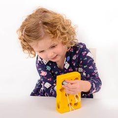 A child putting the mouse through a hole in the cheese