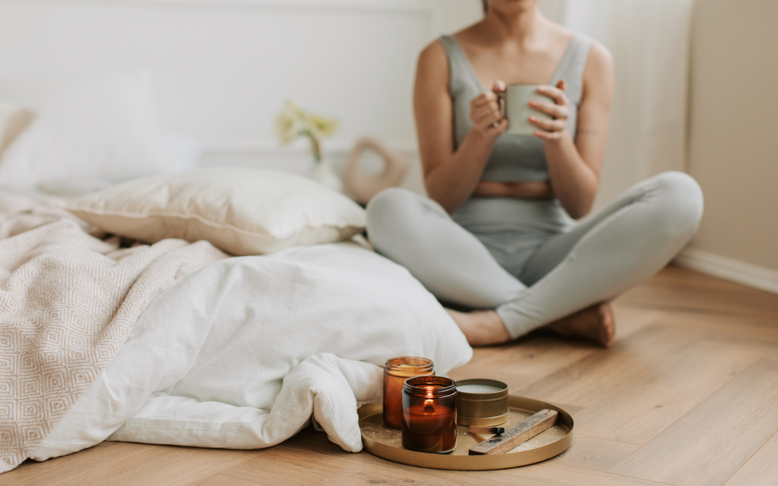 Woman sitting with wood wick candles lit for relaxation