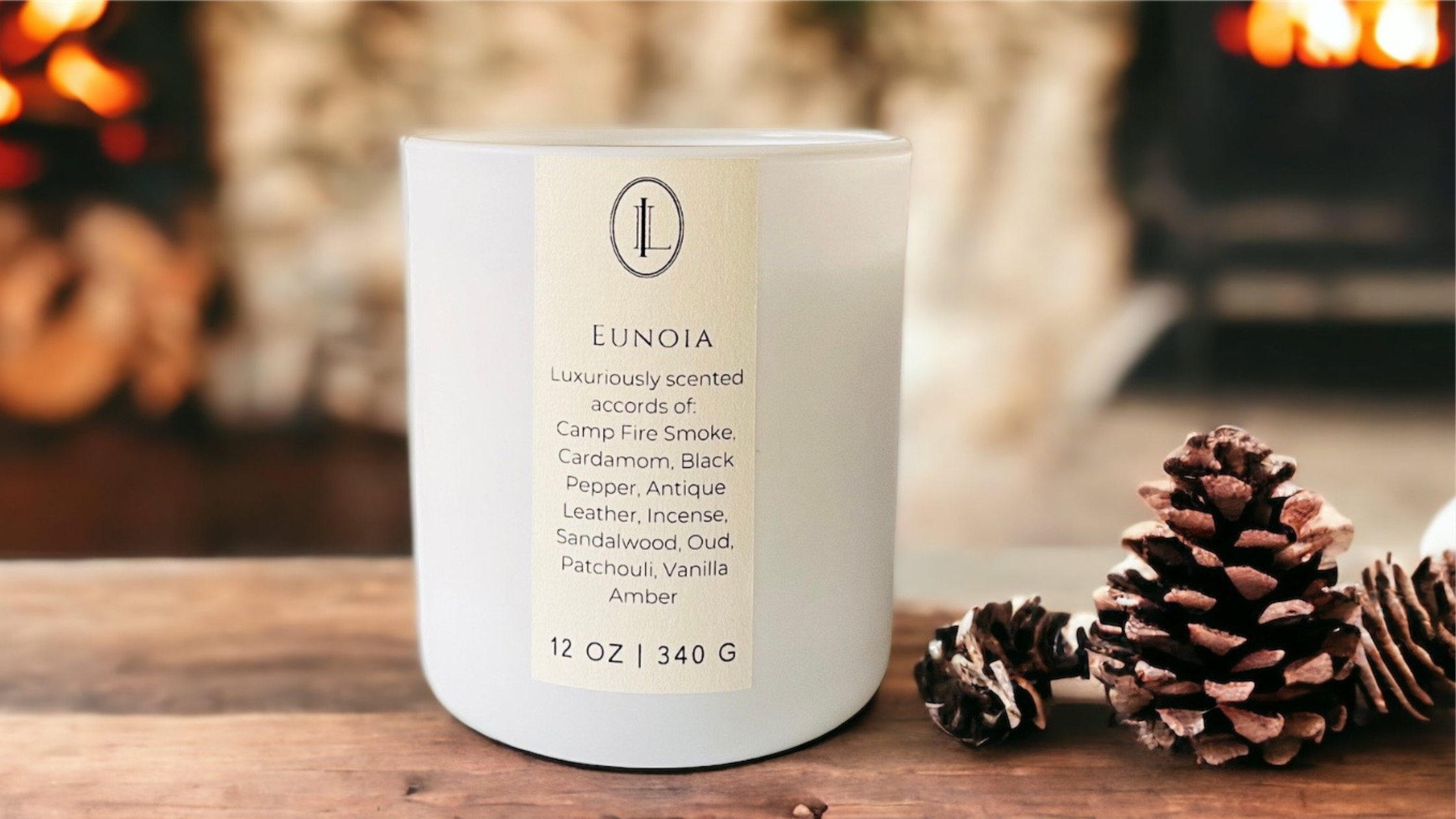 image of Eunoia candle on rustic wood table with pinecones and fireplace in the background