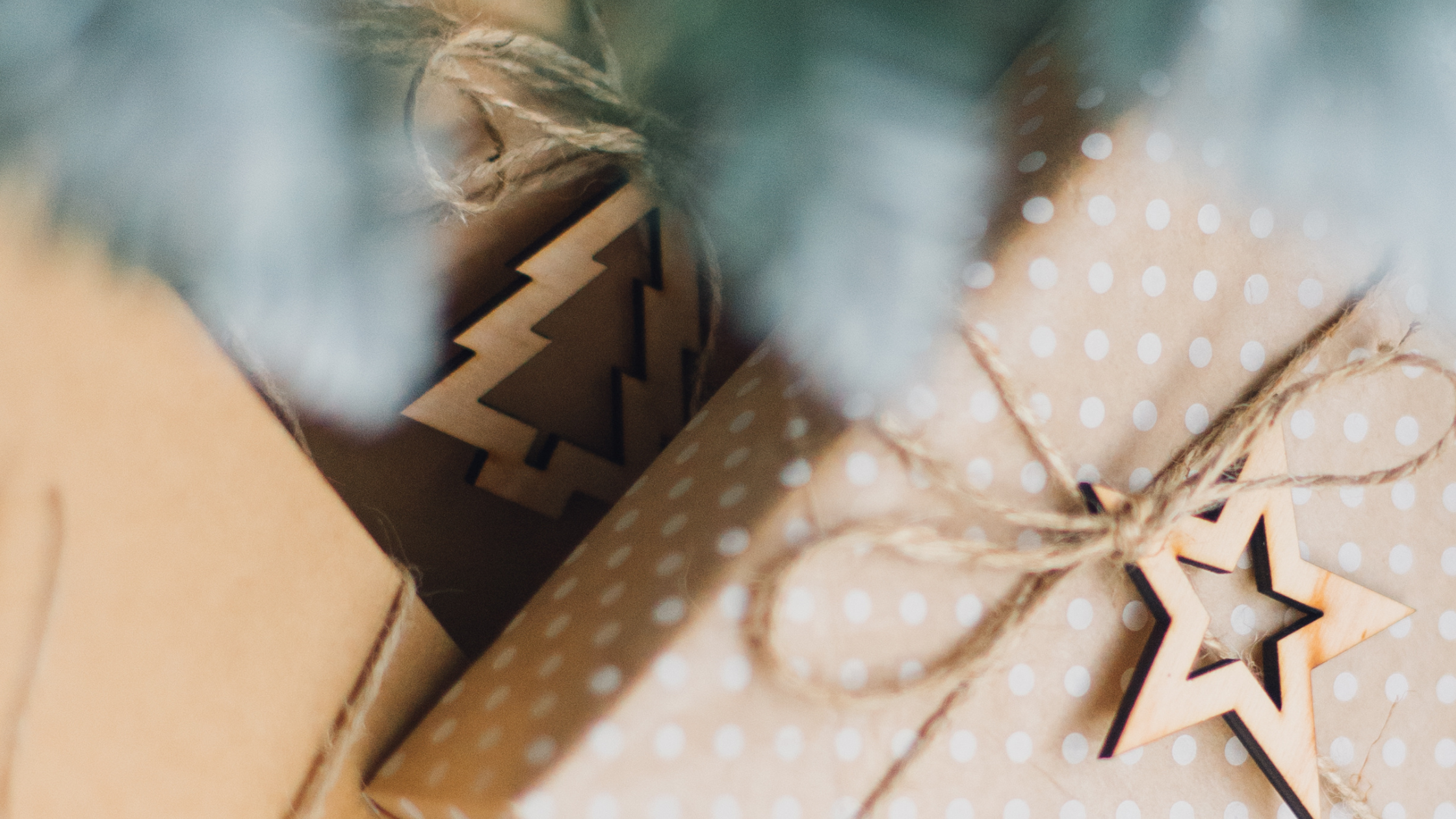 image of wrapped presents in kraft paper with wooden cutout star tag and christmas tree tag
