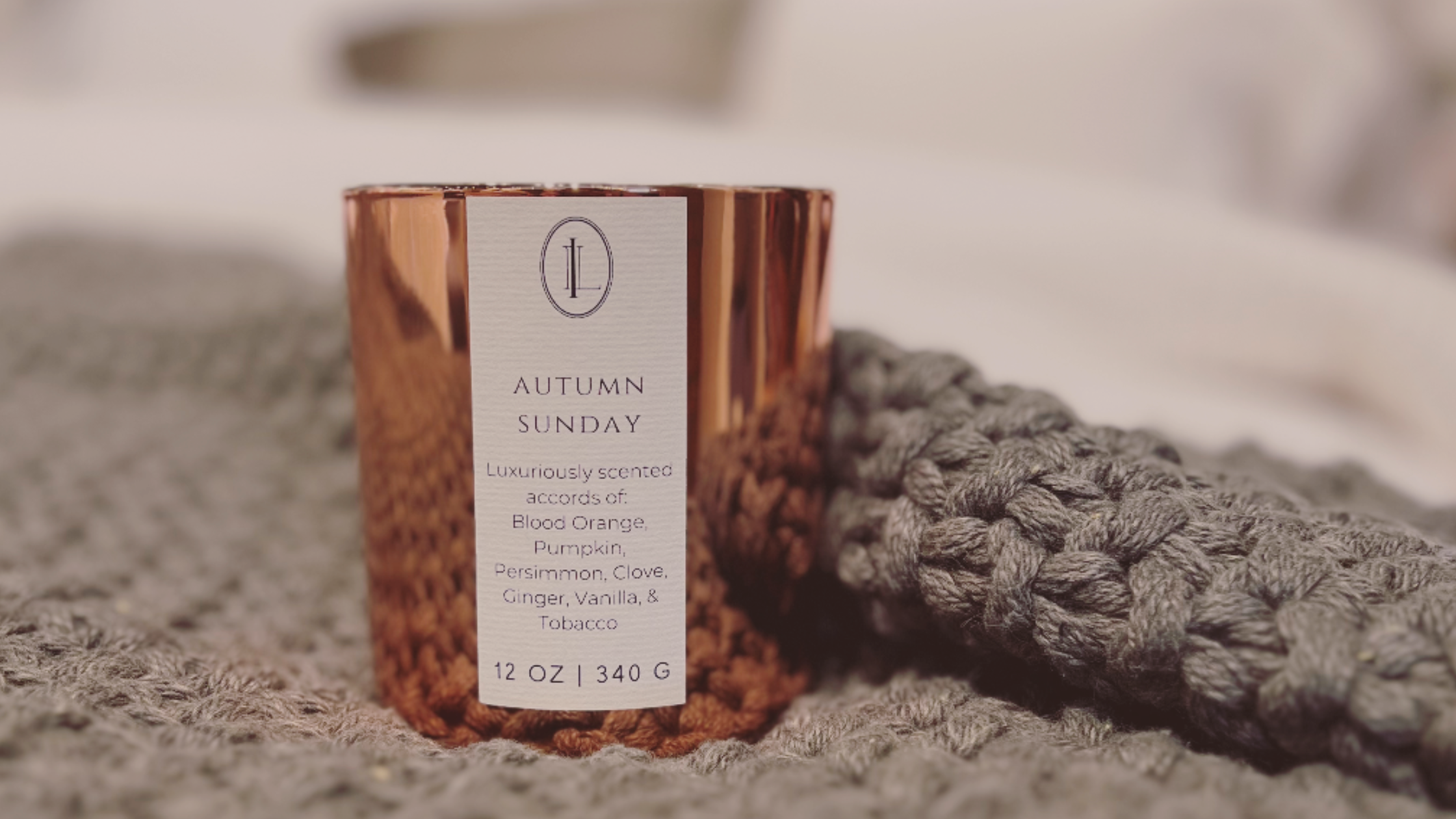 Picture of Autumn Sunday Candle Sitting on a grey chunky knit blanket