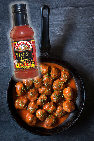 Claude's Hot & Spicy Sauce poured into a cast iron pan with meatballs