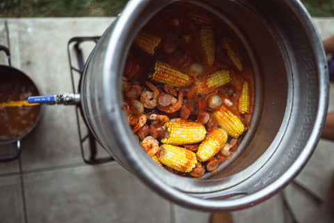 Seafood boil in a large pot being drained