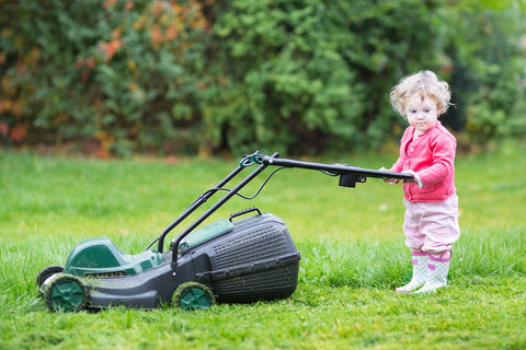 Toddler pushes lawnmower