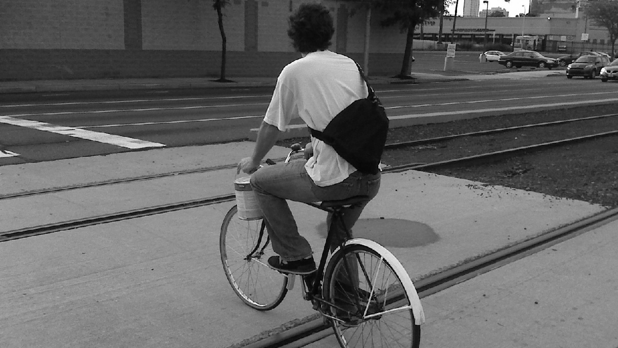 Jaime rides bicycle across train tracks.