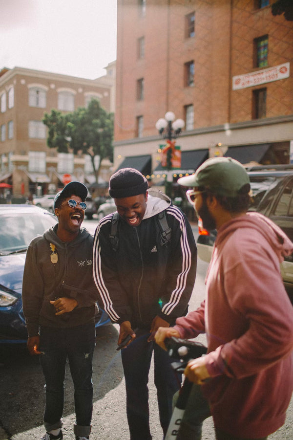 Three men in a group laughing