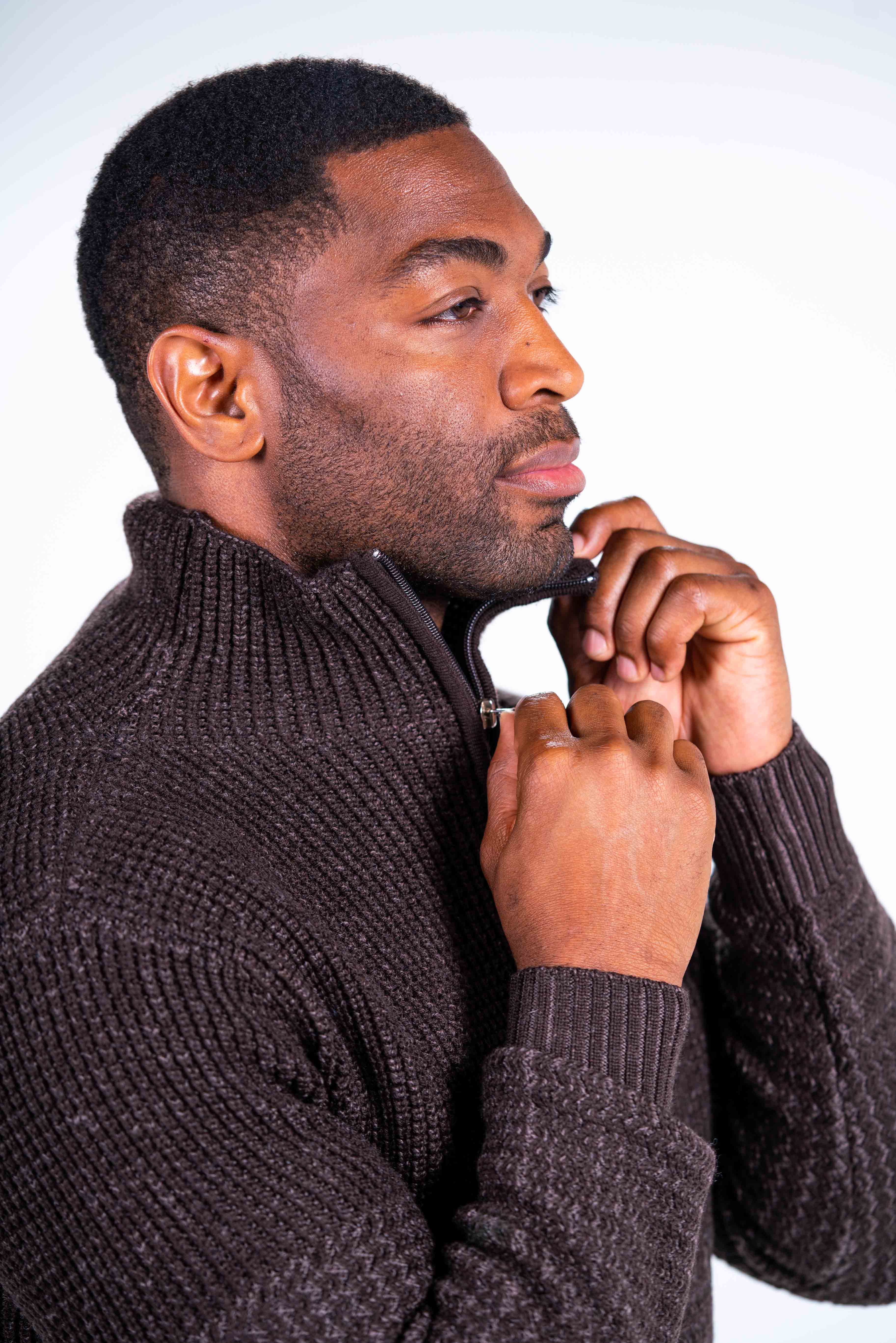 Closeup of the Sahara quarter-zip sweater showing the rib-knit sleeve ends and collar, which also is trimmed and features a silver zipper pull that cinches up the collar all the way to the top.