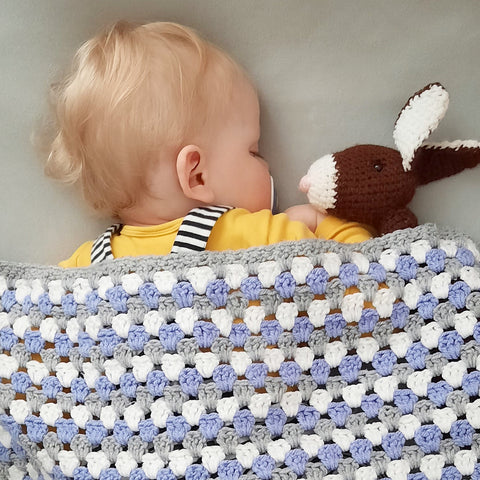 Baby looking cosy under crochet blanket