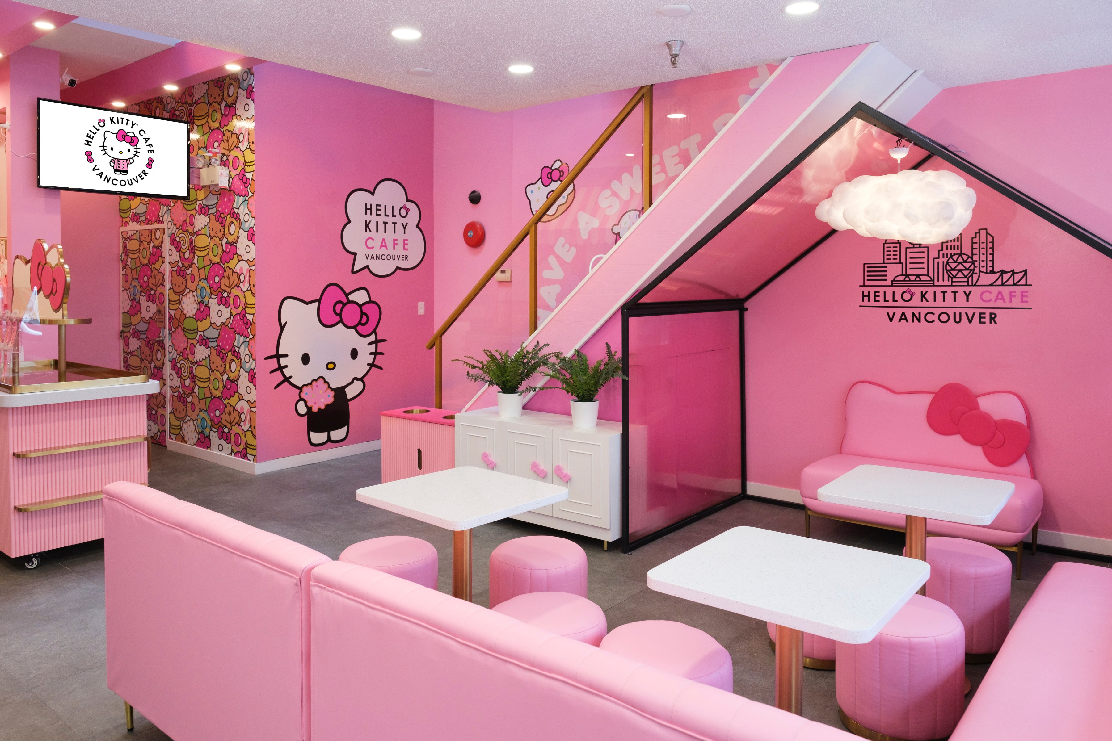 a view of the Vancouver Hello Kitty cafe with pink seats and white table tops