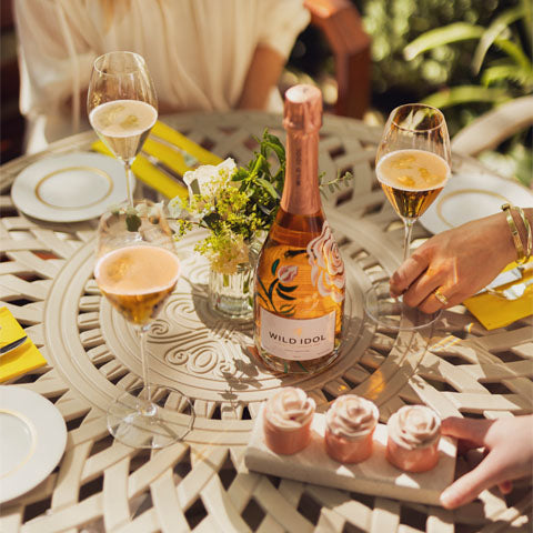 Glasses and bottles of Wild Idol alcohol-free Sparkling Rosé Wine on a talble in Dorchester Gardens