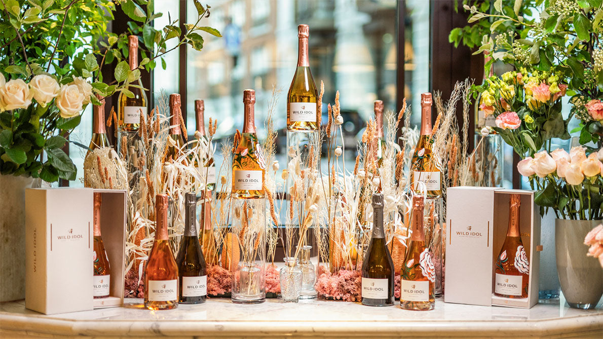 Bottles of Wild Idol alcohol-free Sparkling Wines standing on a floral disaply table