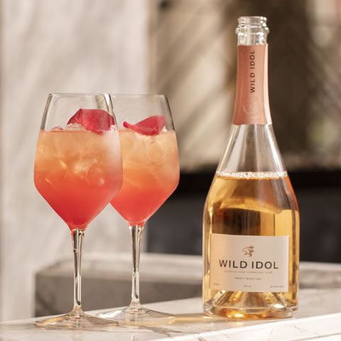 Two Rosé Hugo Cocktails standing next to a bottle of Wild Idol Alcohol Free Sparkling Rosé Wine
