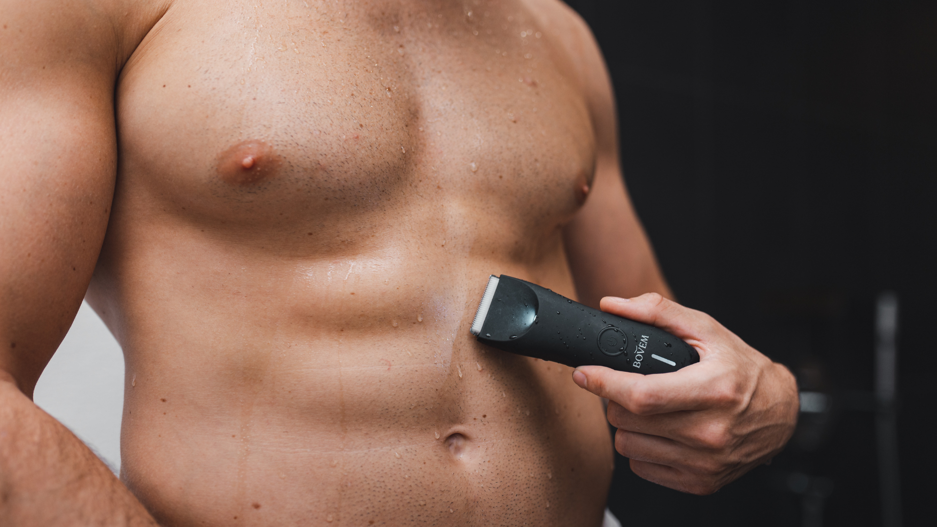 Man shaving his chest, stomach and pubes with BOVEM Globe trimmer. 