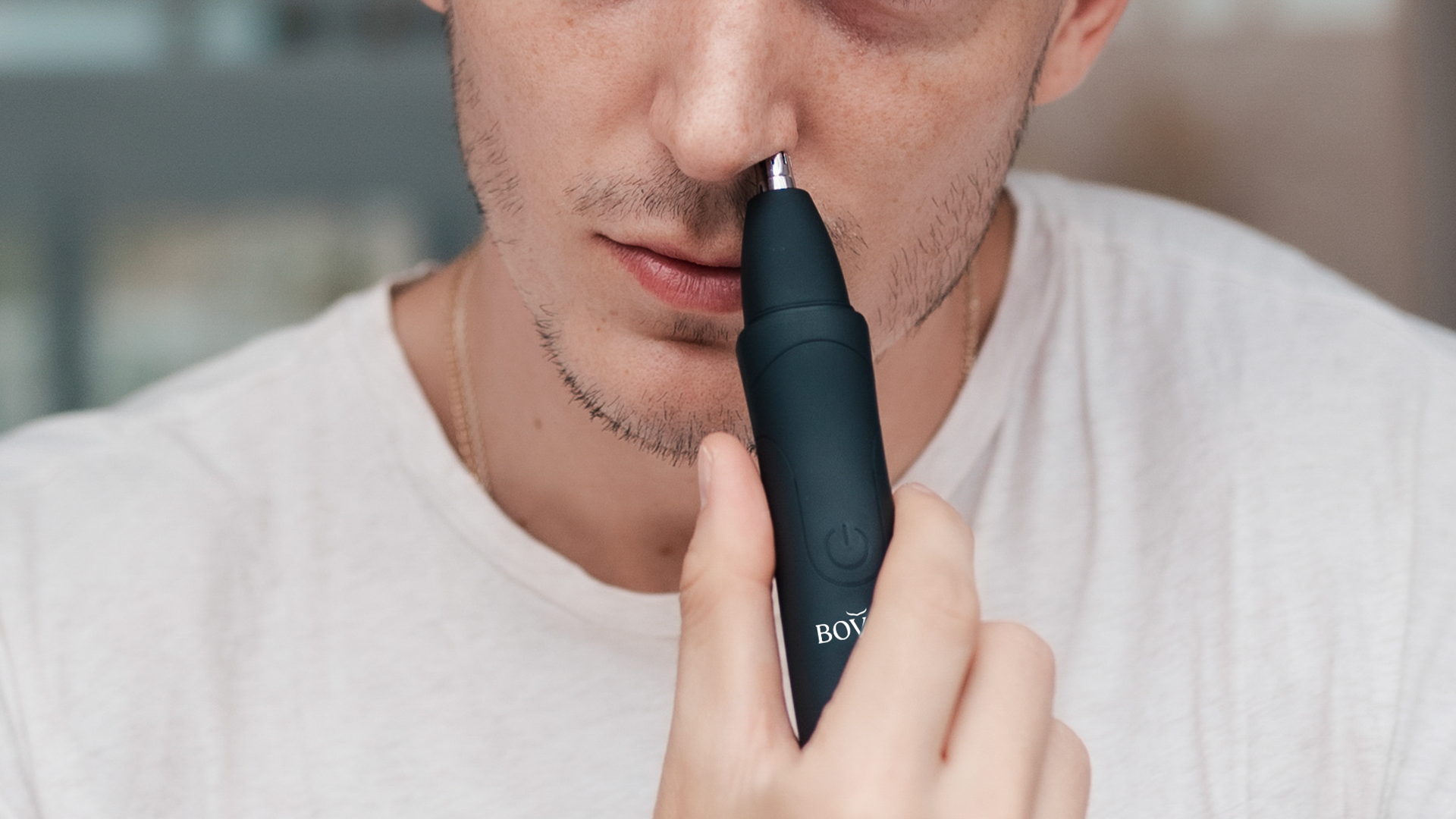 electric nose trimmer in hand being used in mirror