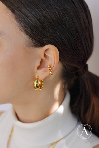 Se muestra una modelo usando unos ear cuffs arriba de su arete normal