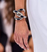 Muestra una pulsera chunky plateada en el brazo de una modelo