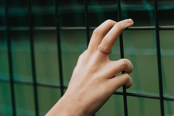 hand holding a black fence