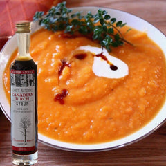 Photo of roasted yam soup with cardamom cream and birch syrup swirl just about to be served.