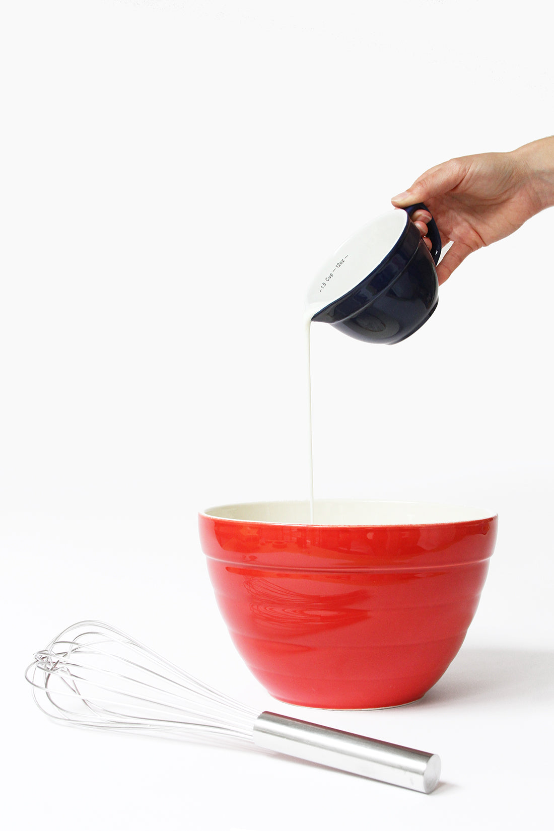 Image of buttermilk poured into a red mixing bowl for Miss Jones Baking Co Blackberry Buttermilk Donuts