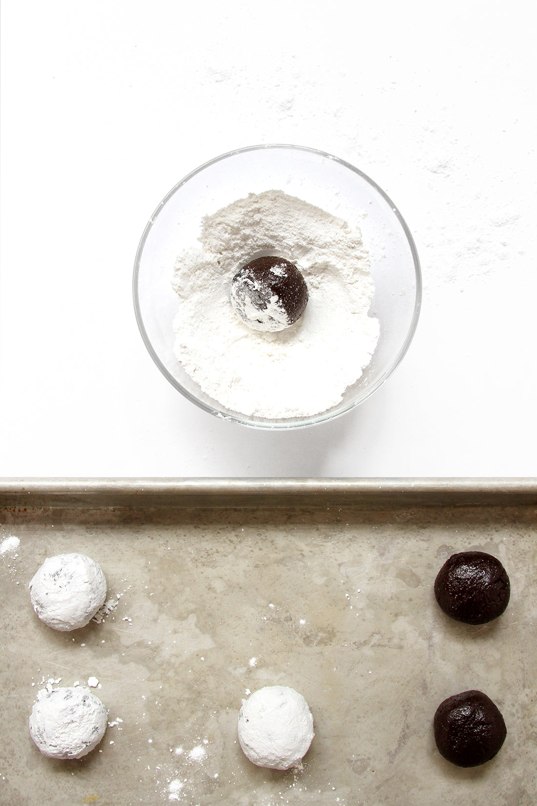 Image of Miss Jones Baking Co Brownie Batter Crinkle Cookie Sandwich dough balls being dipped in powdered sugar