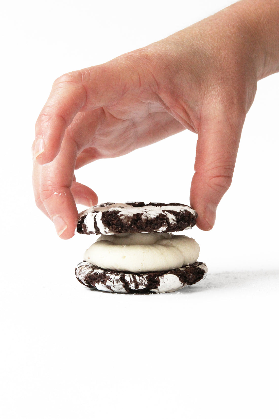 Image of hand putting top layer onto a Miss Jones Baking Co Brownie Batter Crinkle Cookie Sandwich