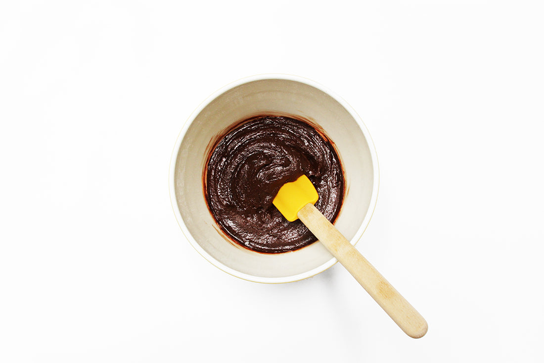 Image from above of Miss Jones brownie batter in a mixing bowl with a yellow spatula used for Miss Jones Baking Co Coffee Break Shake