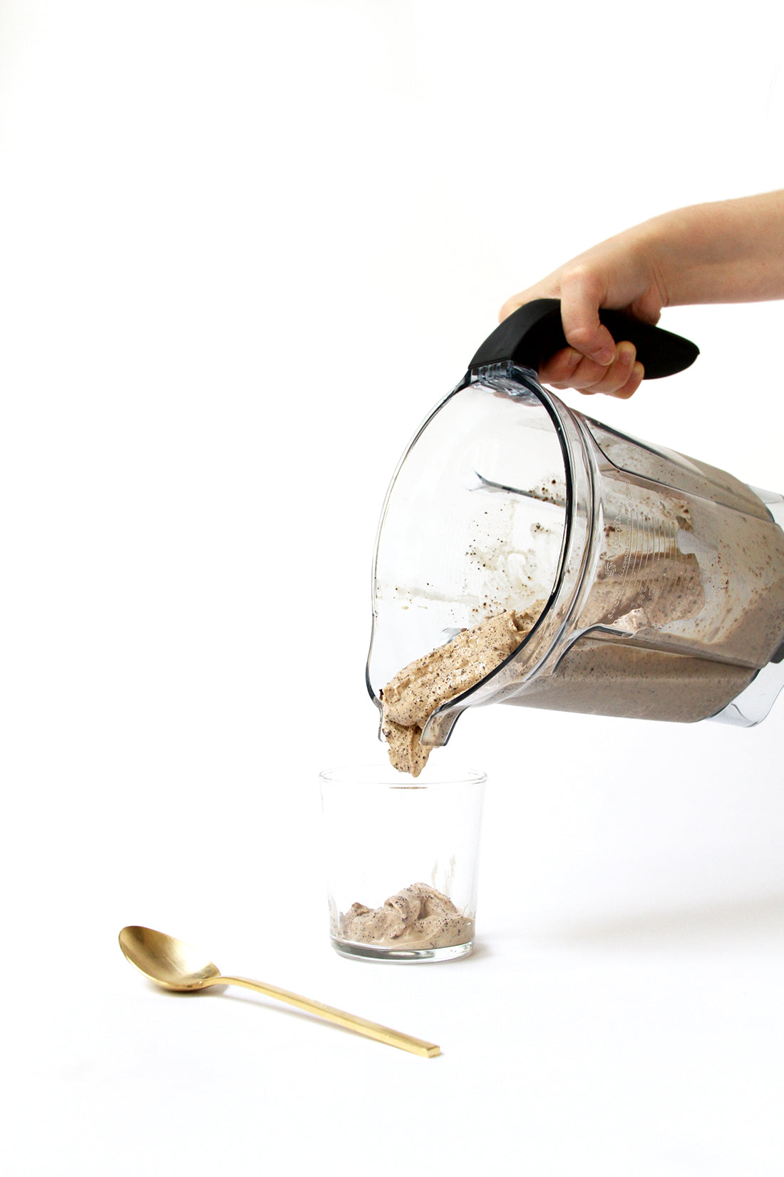 Image of a hand pouring Miss Jones Baking Co Coffee Break Shake into a cup from a blender next to a gold spoon