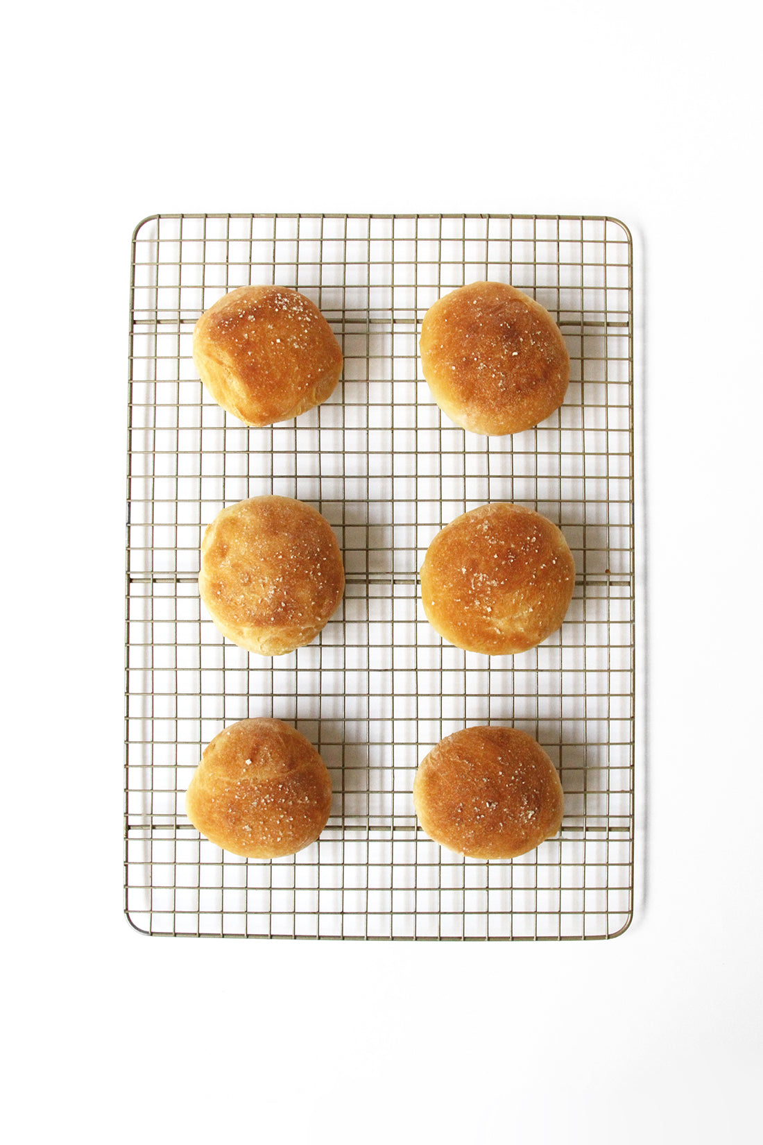 Image of six cooked Miss Jones Baking Co Cake Mix Dinner Rolls on baking rack