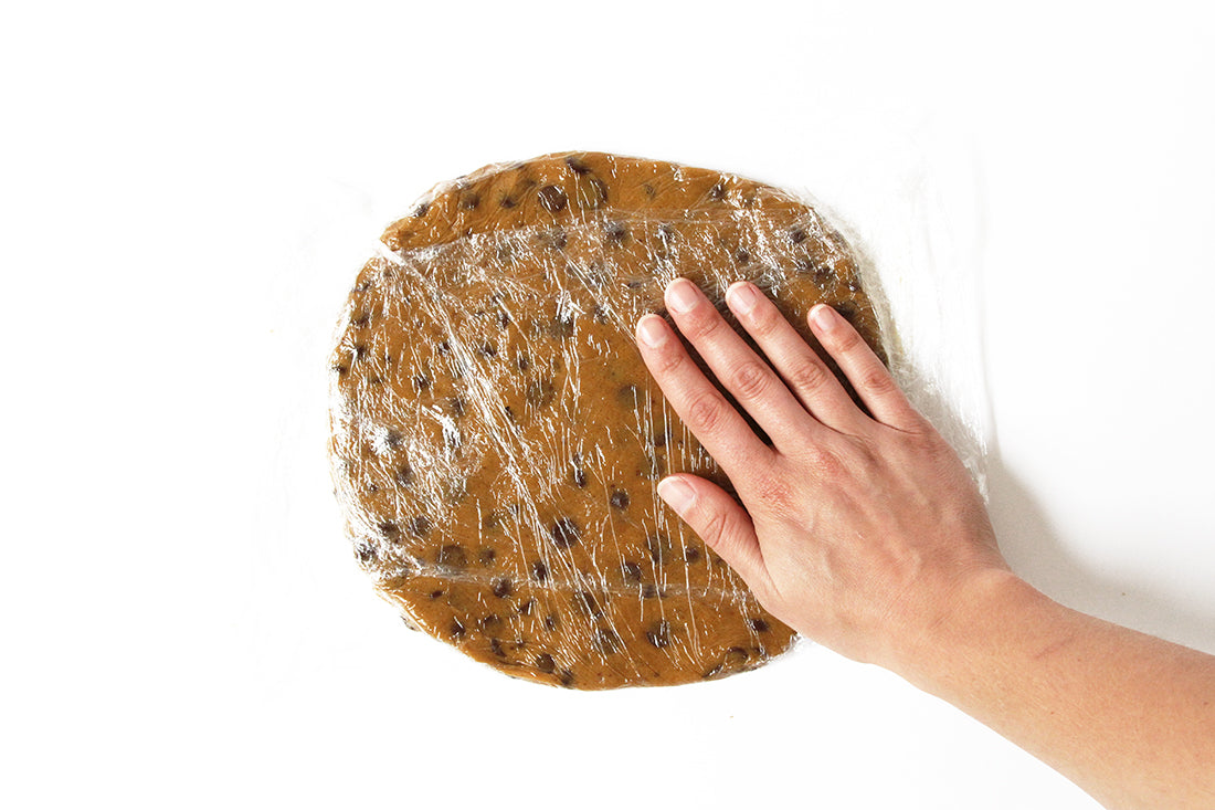 Flattened cookie dough covered in plastic wrap used for Miss Jones Baking Co Chocolate Chip Brownie Skillet